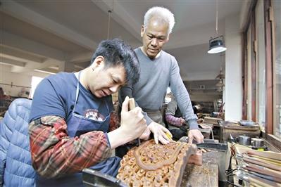 中國僑網(wǎng)胡敏強（右）在指導(dǎo)年輕人雕刻紅木。 